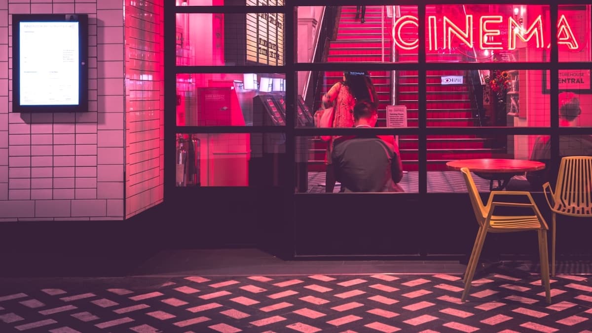 A cinema facade illuminated with neon lights representing the vibrant Korean entertainment industry