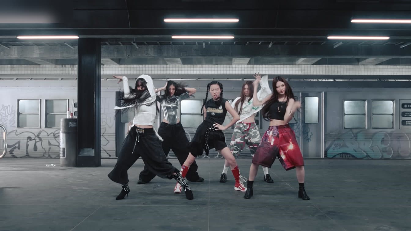 A vibrant K-pop performance stage with colorful lights, representing MEOVV's energetic debut era